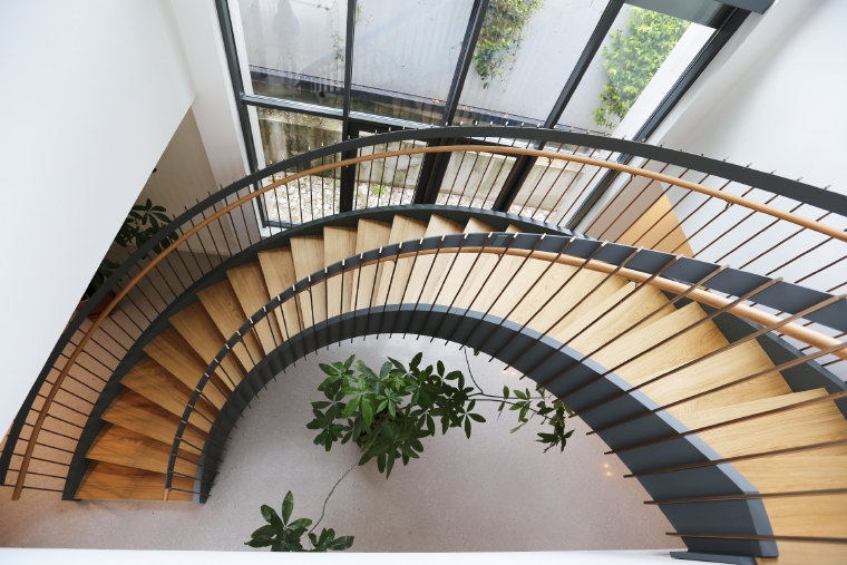 Escalier courbe marches en bois rampe en métal